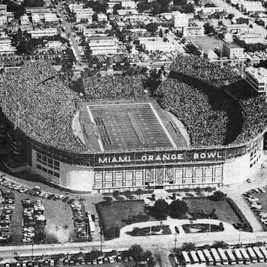 A college football game underway in a stadium, with players on the field.